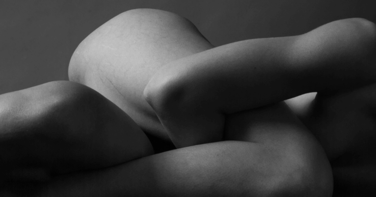 Frau liegt still und sanft umhüllt auf einer weichen Unterlage, der Körper entspannt, die Augen geschlossen – ein Moment tiefer Selbstverbindung und somatischer Beziehungsheilung.